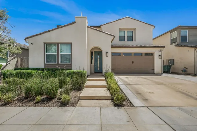 a front view of a house with a garden