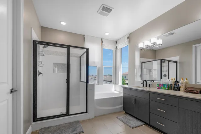 a spacious bathroom with a double vanity sink a mirror and a bathtub