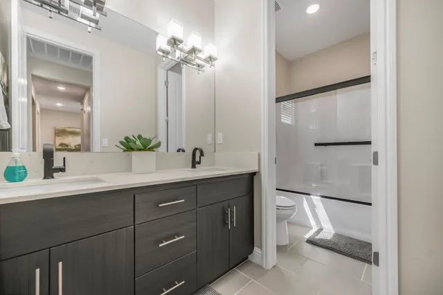 a spacious bathroom with a double vanity sink mirror and toilet