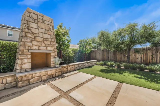 a view of a backyard with potted plants and wooden fence