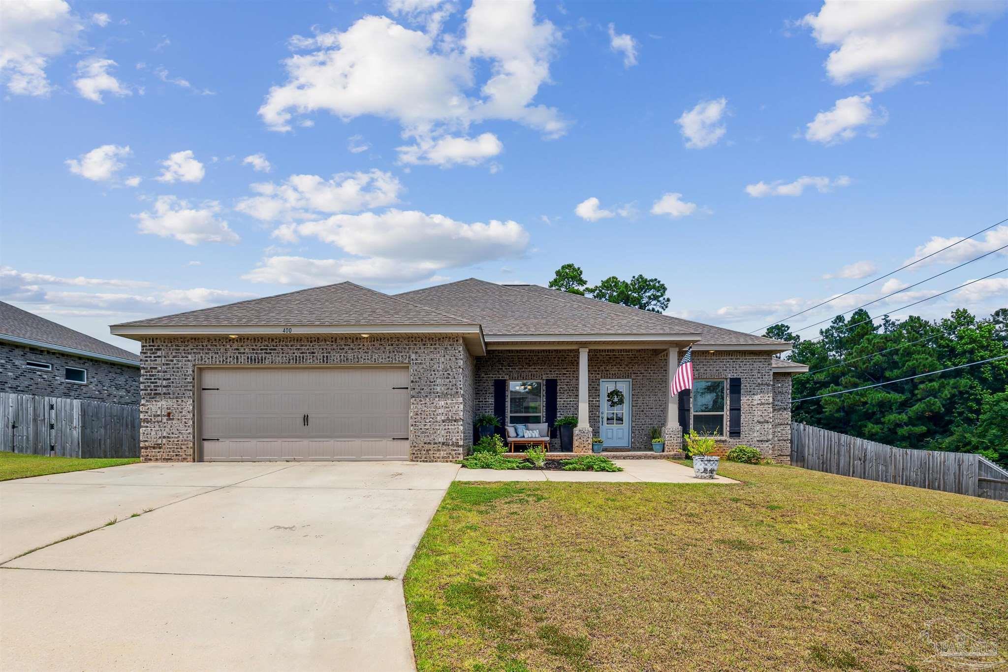 400 Broadleaf Circle Cantonment, FL 32533 - Photo 1 of 21 a view of a white house with a fountain and a large tree