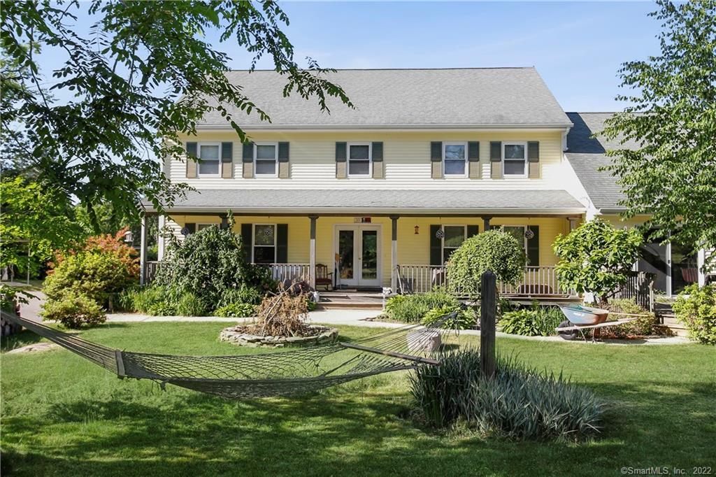 a front view of a house with garden and sitting area
