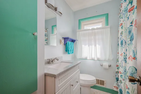 a bathroom with a granite countertop sink a toilet and a mirror