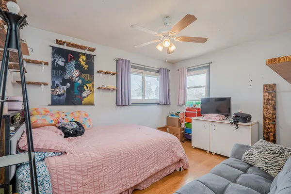 a bedroom with a bed and wooden floor
