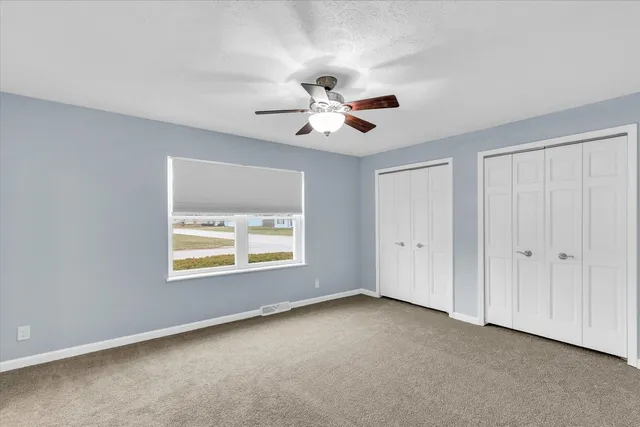 a view of room with a ceiling fan and a window