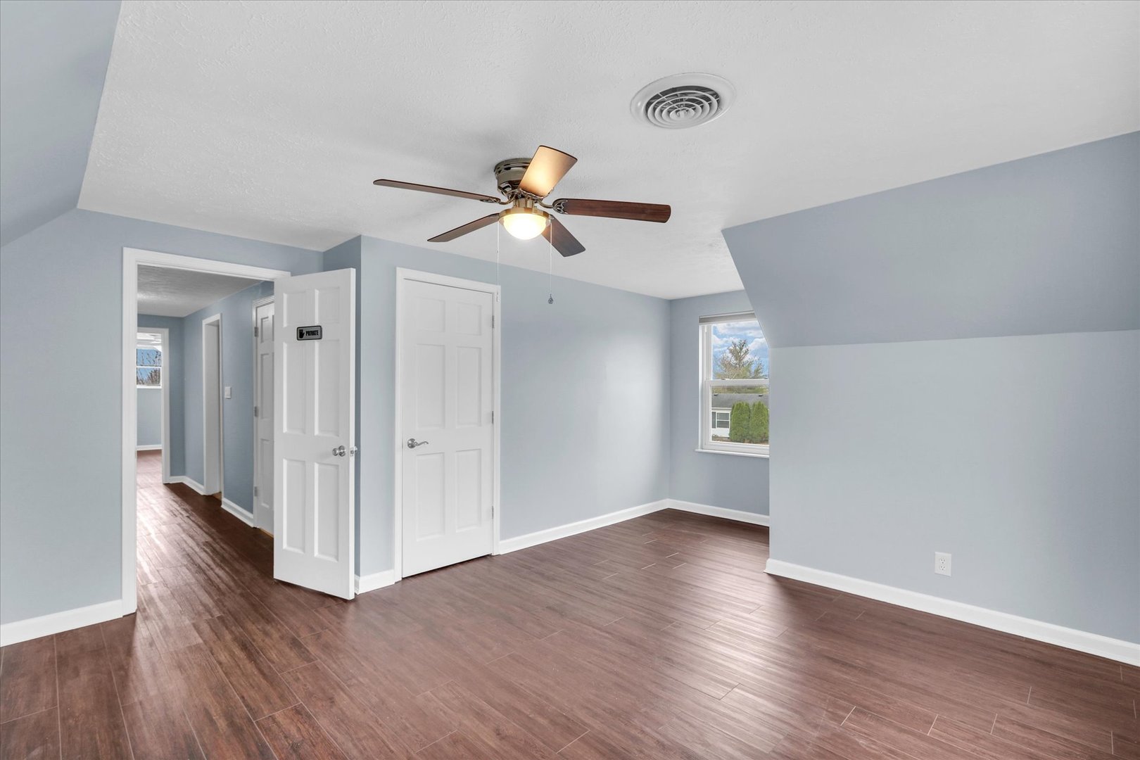 2302 Pheasant Ridge Road Mahomet, IL 61853 - Photo 19 of 31 a view of a room with wooden floor and a ceiling fan