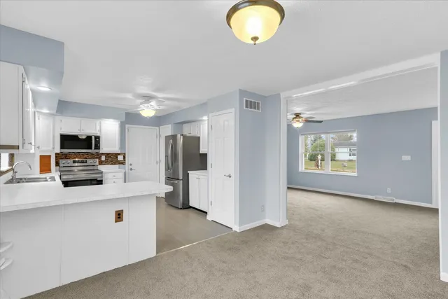 a large white kitchen with stainless steel appliances granite countertop lots of counter top space
