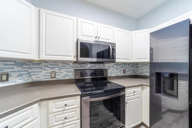 a kitchen with granite countertop a stove top oven microwave and cabinets