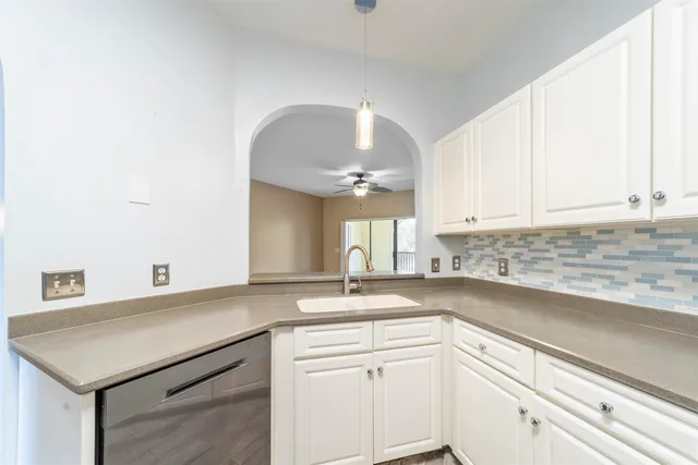 a kitchen with granite countertop a sink white cabinets and a granite counter tops