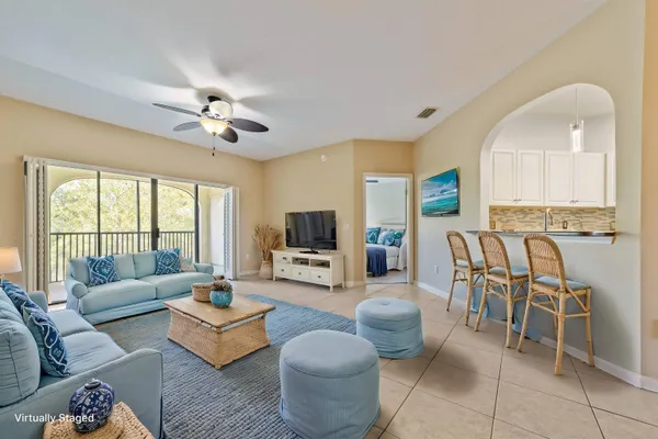a living room with furniture a flat screen tv and a large window