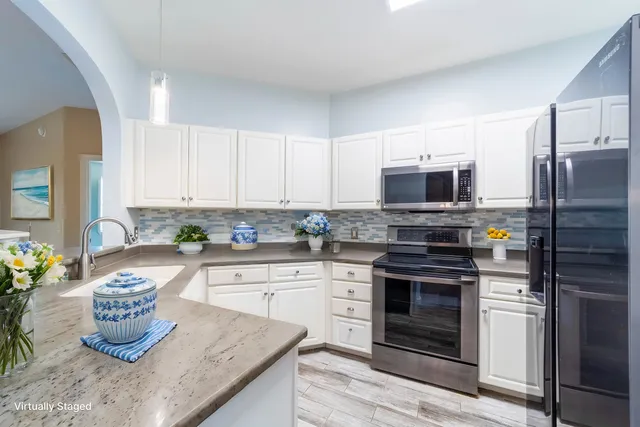 a kitchen with granite countertop stainless steel appliances and wooden cabinets