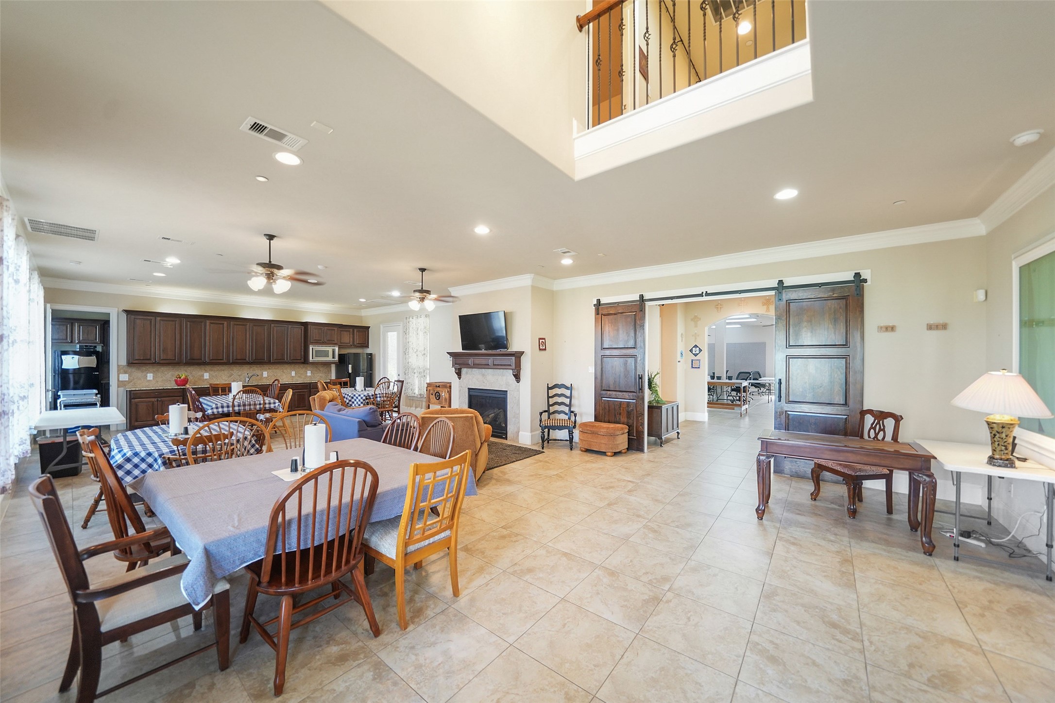 26250 A Riley Road Waller, TX 77484 - Photo 35 of 50 Open retreat living/dining/kitchen with gas fireplace, two dining areas, and patio access—comfortable flow for hosting.