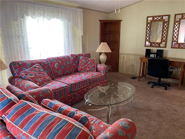 a living room with furniture a rug and a window