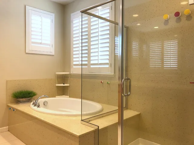 a bathroom with a granite countertop tub and a shower
