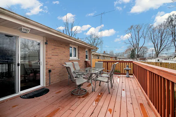 a view of a roof deck with table and chairs with wooden floor and fence