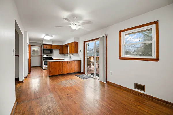 a view of a room with wooden floor and a kitchen