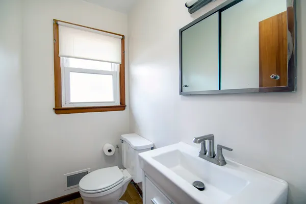 a bathroom with a toilet sink and mirror