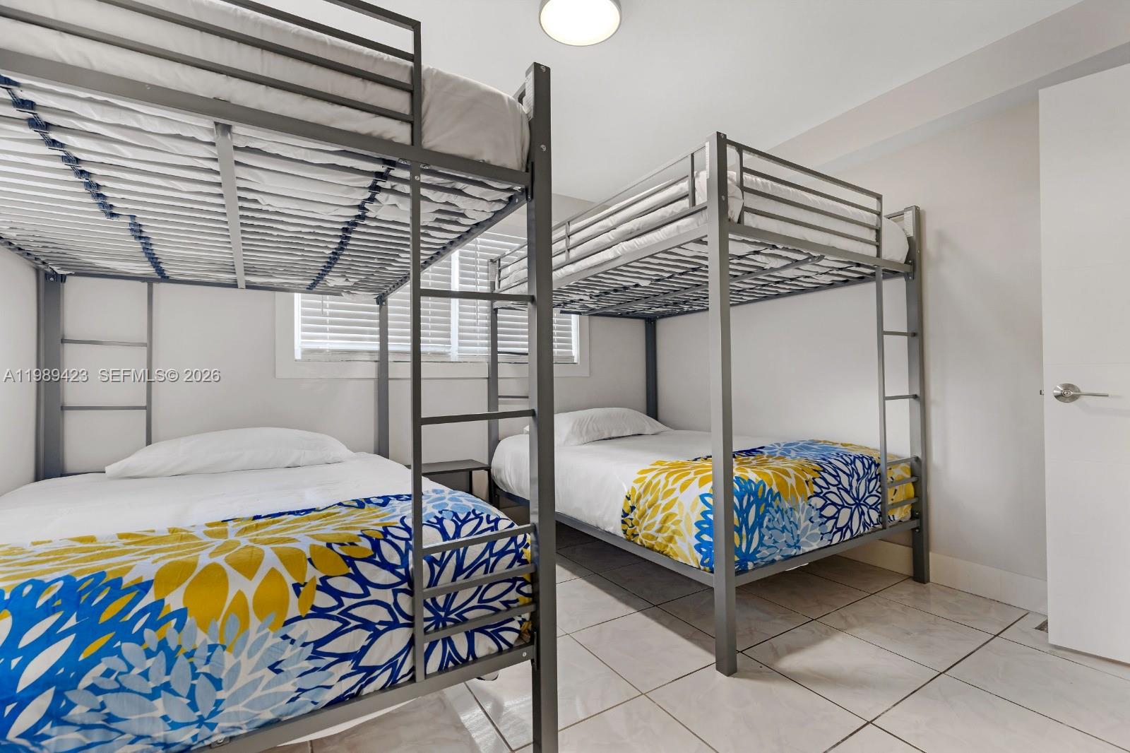 38 Miami Gardens Road West Park, FL 33023 - Photo 16 of 30 a bedroom with bed and a chandelier