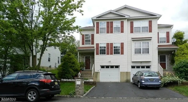 a front view of a house with cars parked