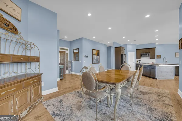 a room with stainless steel appliances kitchen island granite countertop a sink and cabinets