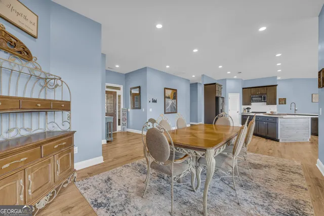 a room with stainless steel appliances kitchen island granite countertop a sink and cabinets