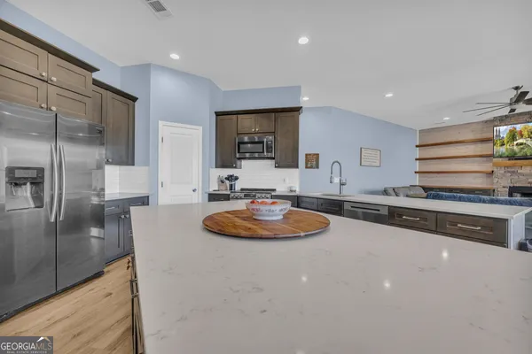 a large living room with stainless steel appliances granite countertop furniture and a large window