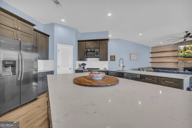 a large living room with stainless steel appliances granite countertop furniture and a large window