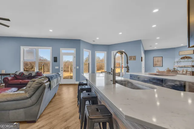a view of a kitchen with stainless steel appliances granite countertop a sink and a counter top space