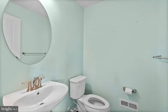 a view of an empty room with a kitchen stove and wooden floor