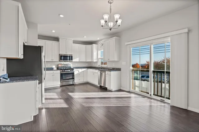 a kitchen with granite countertop a refrigerator stove top oven and sink