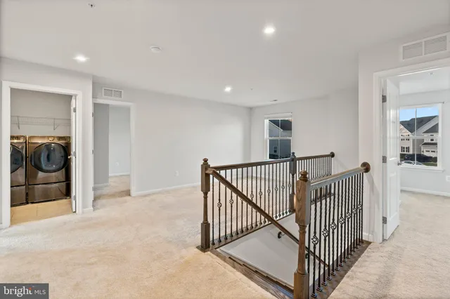 a view of an empty room and chandelier fan