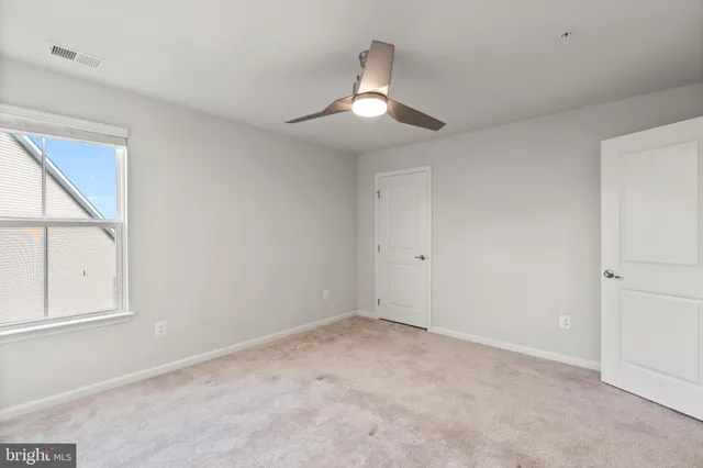 a view of an empty room with a ceiling fan