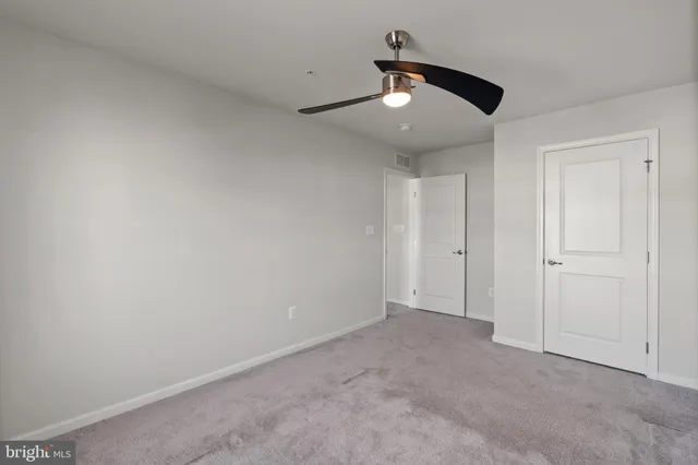 a spacious bedroom with a large bed and a chandelier