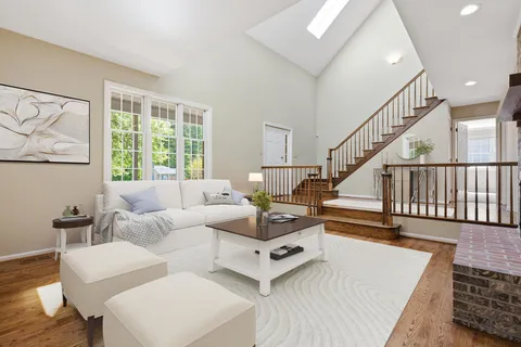 a living room with furniture and a table with wooden floor