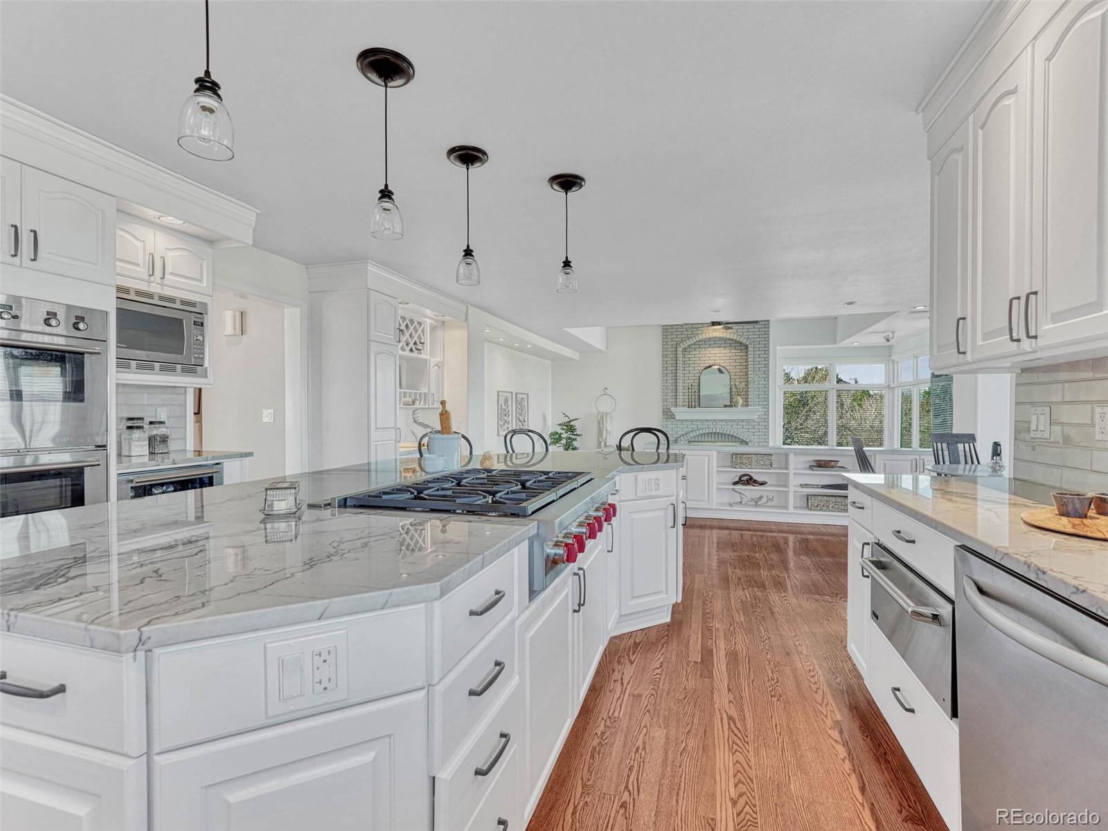 8541 Colonial Drive Lone Tree, CO 80124 - Photo 13 of 45 a large kitchen with stainless steel appliances granite countertop a lot of counter space and wooden floors