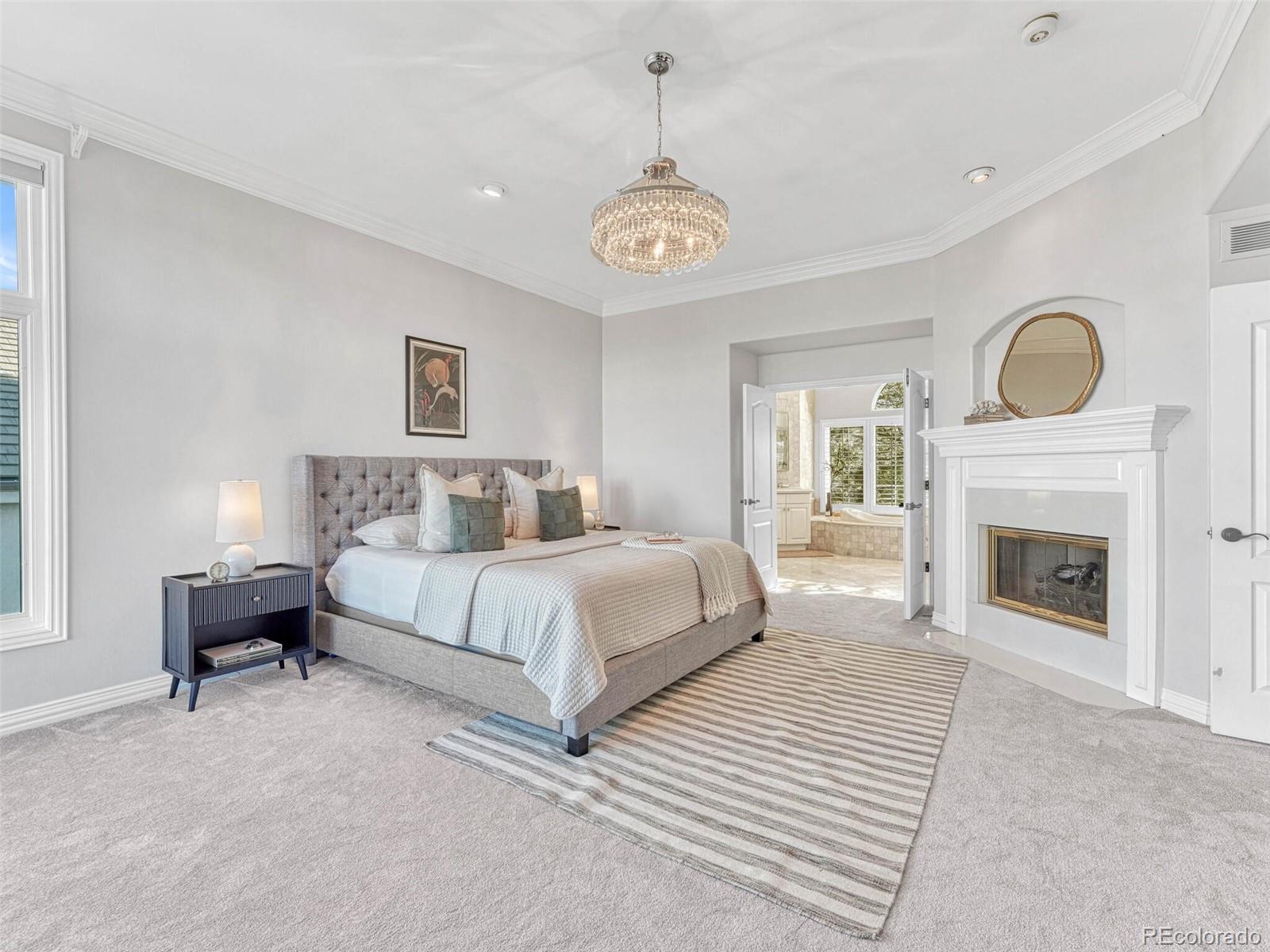 8541 Colonial Drive Lone Tree, CO 80124 - Photo 22 of 45 a spacious bedroom with a bed and a fireplace