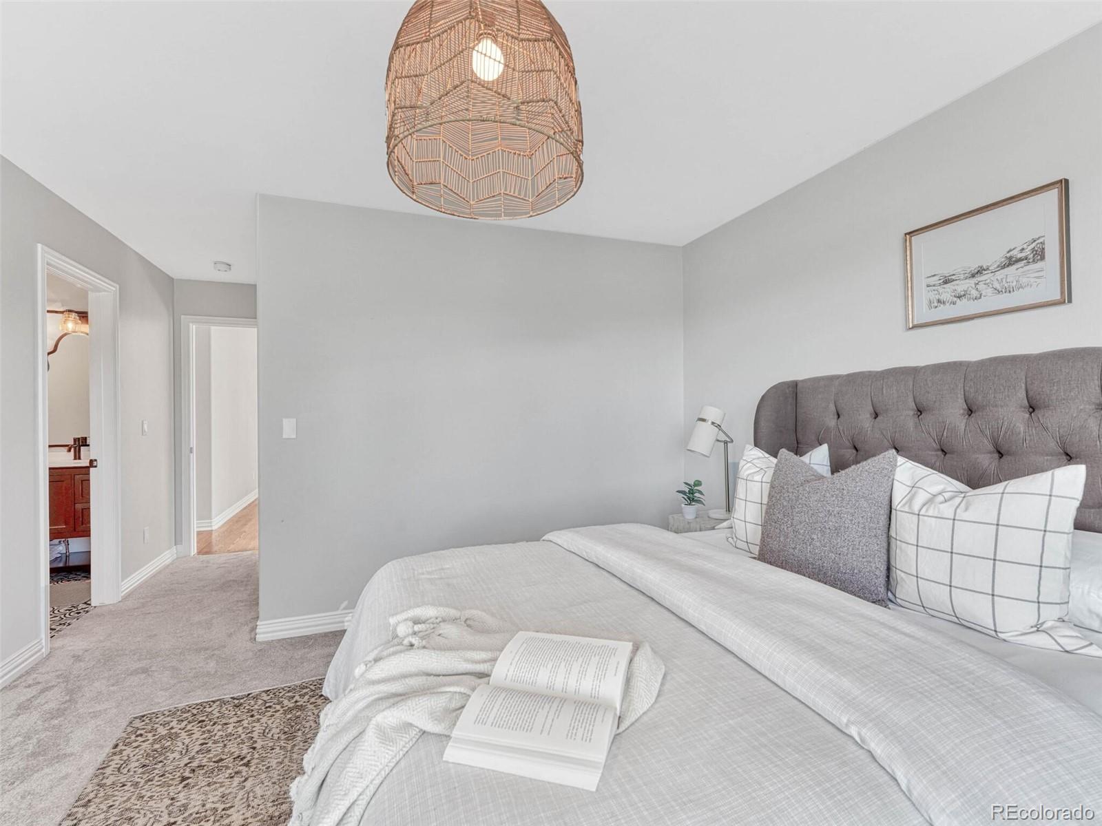 8541 Colonial Drive Lone Tree, CO 80124 - Photo 28 of 45 a bedroom with a bed and a chandelier