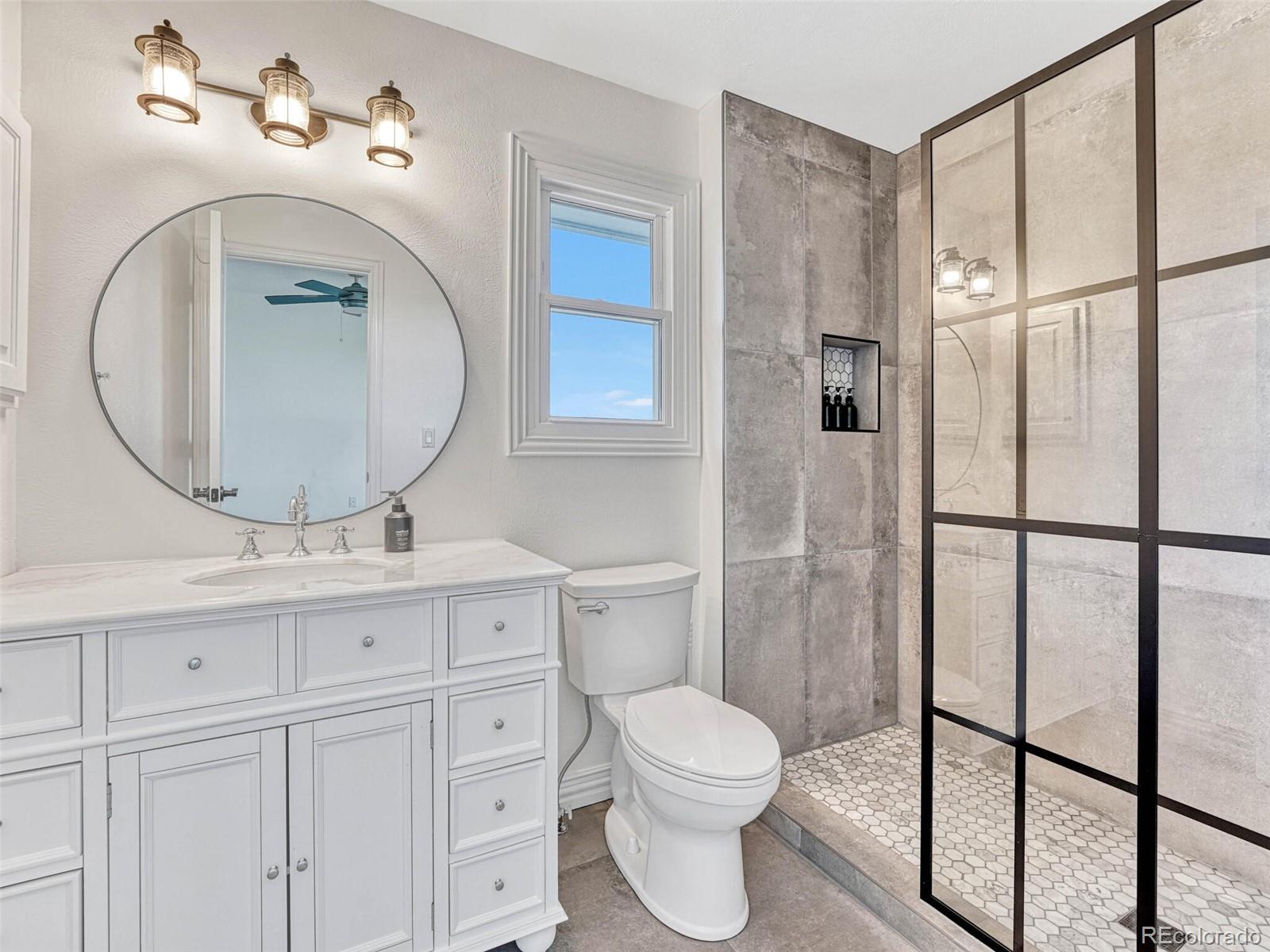8541 Colonial Drive Lone Tree, CO 80124 - Photo 30 of 45 a bathroom with a toilet a sink and a mirror