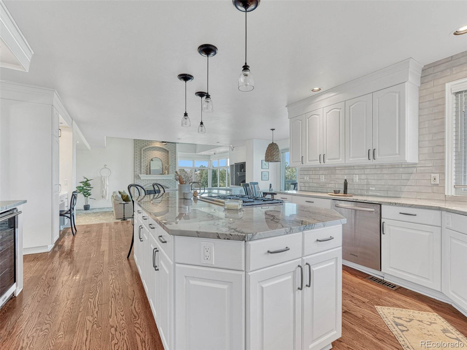 8541 Colonial Drive Lone Tree, CO 80124 - Photo 9 of 45 a kitchen with kitchen island granite countertop a sink cabinets and wooden floor