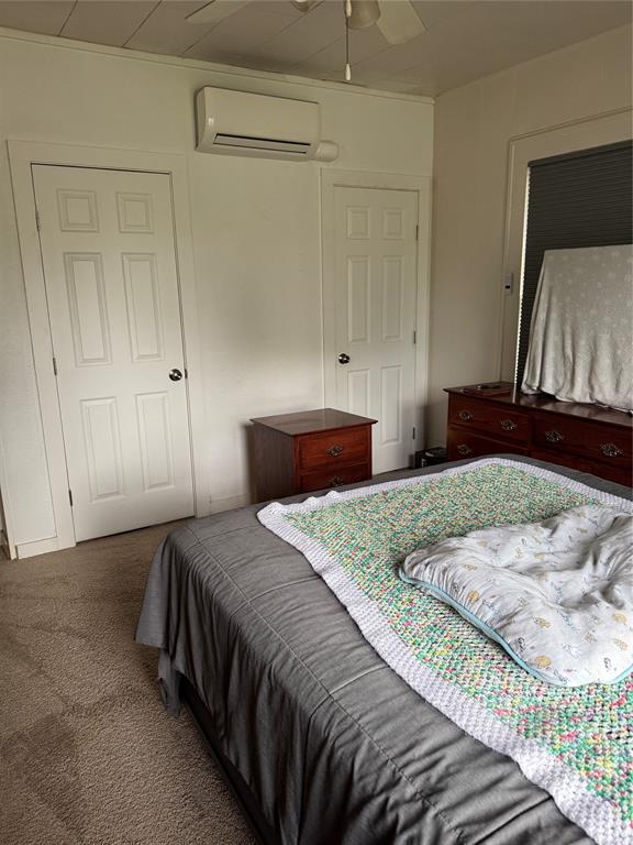 2300 Lyle Avenue Waco, TX 76708 - Photo 15 of 23 Bedroom featuring dark carpet, a wall mounted mini split, and a ceiling fan