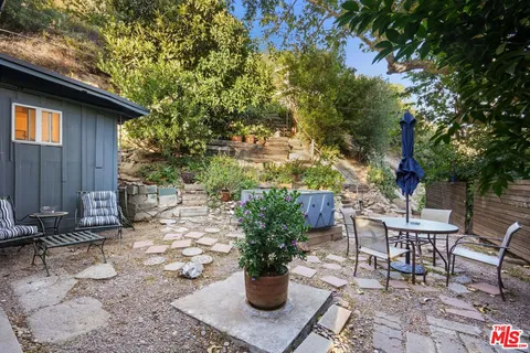 a view of a chairs and table in backyard of the house