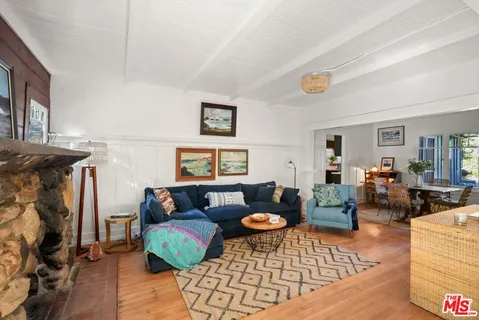 a living room with furniture a fireplace and a large window