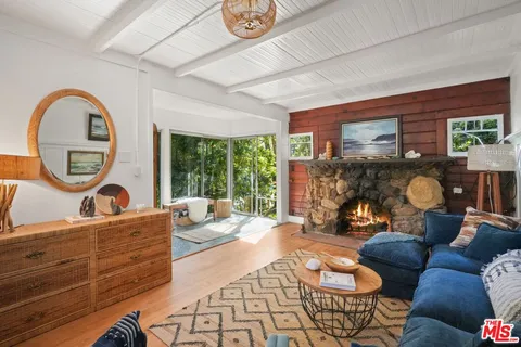 a living room with furniture a window and potted plants