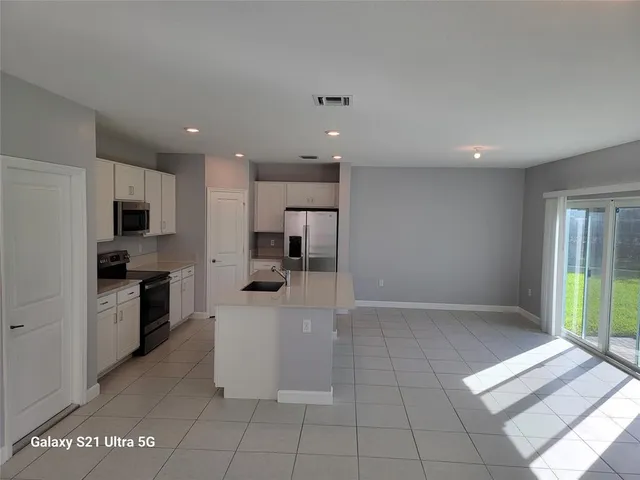 a large kitchen with a large counter top stainless steel appliances and cabinets