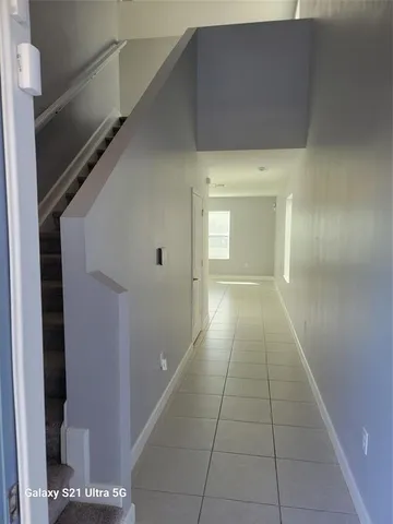 a view of a hallway with wooden floor and a living room