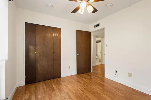 a big room with wooden floor and chandelier fan