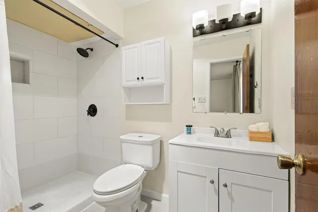 a bathroom with a granite countertop toilet sink and a mirror