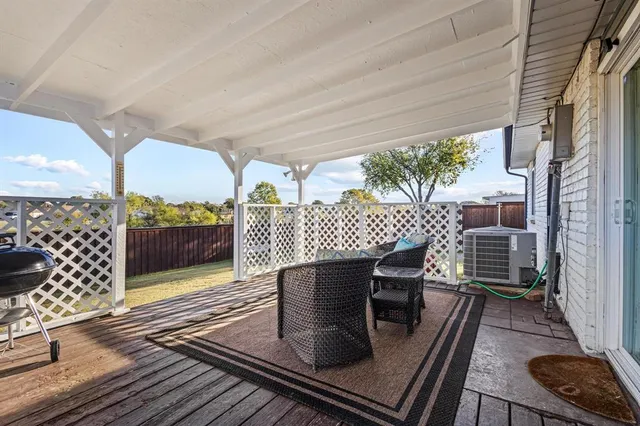 a view of a patio with a dining table and chairs with wooden floor