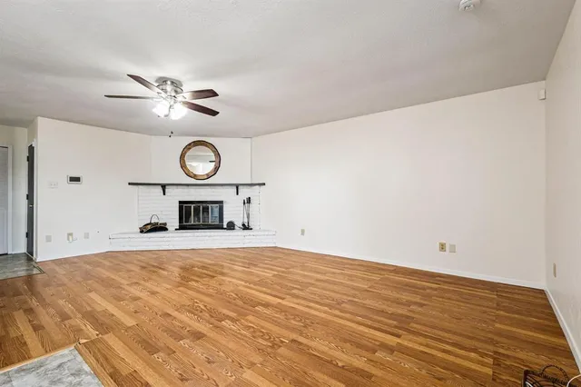 a view of an empty room with a fireplace and a window
