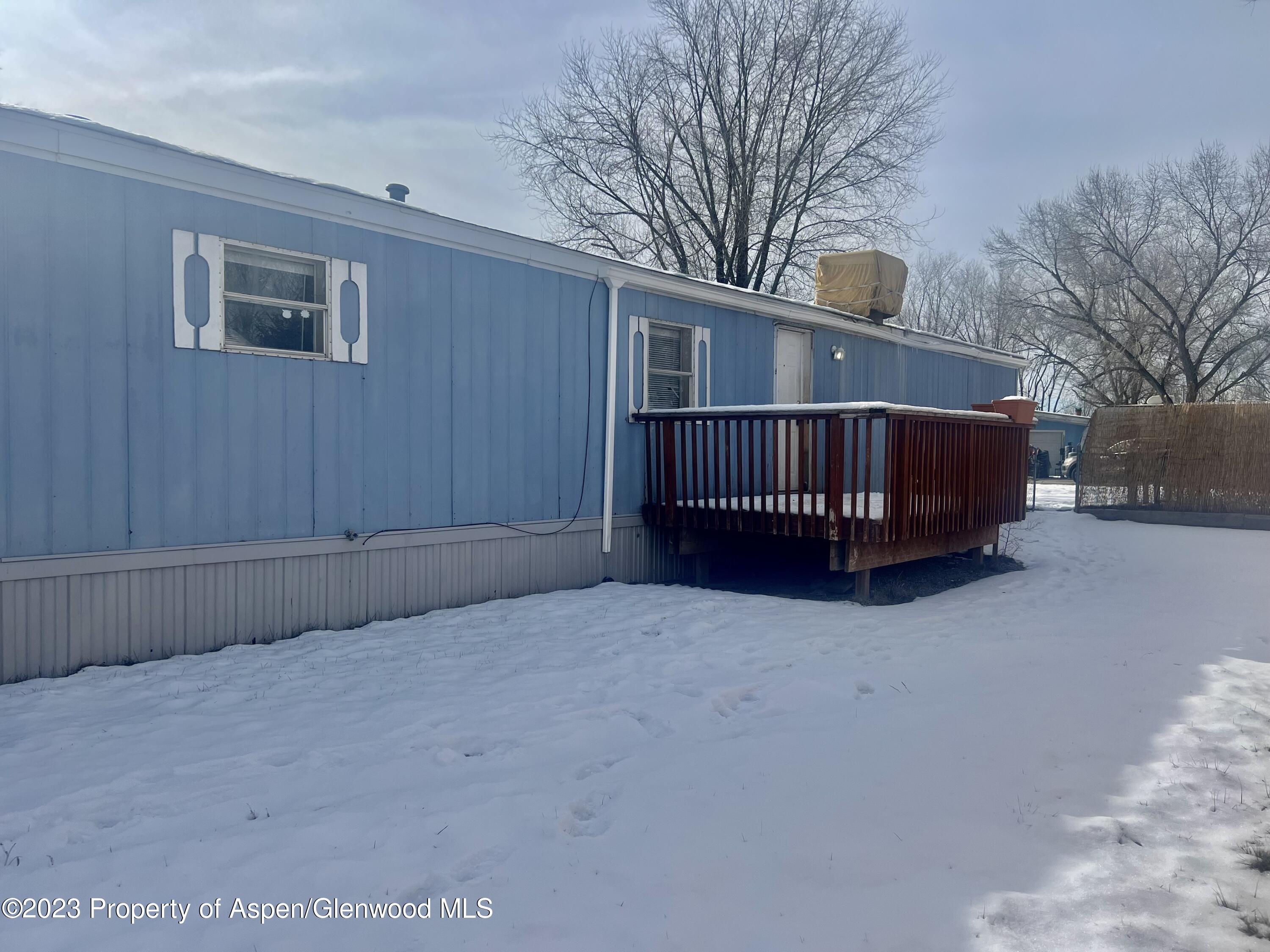 346 Greig Avenue De Beque, CO 81630 - Photo 15 of 15 a view of a house with a wooden bench in a yard